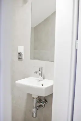 a white sink in a bathroom with a mirror at Spokojna Apartamenty in Trzebinia