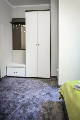 a bedroom with white cabinets and a purple rug at Rajska Oaza in Przybradz