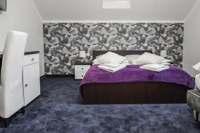 a bedroom with a purple bed with a purple blanket at Rajska Oaza in Przybradz