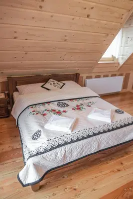 a bedroom with a bed in a wooden room at Rajska Oaza in Przybradz