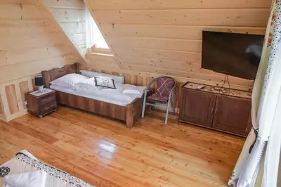 a bedroom with a bed and a flat screen tv at Rajska Oaza in Przybradz