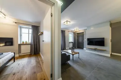 a living room with a bed and a tv at Groble Residence WAWELOFTS in Kraków
