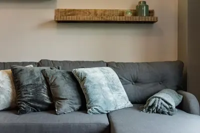 a gray couch with pillows on top of it at Groble Residence WAWELOFTS in Kraków