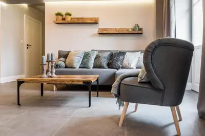 a living room with a couch and a table and a chair at Groble Residence WAWELOFTS in Kraków