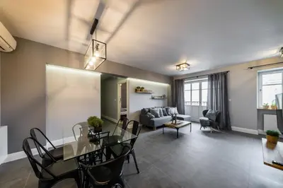 a dining room and living room with a table and chairs at Groble Residence WAWELOFTS in Kraków