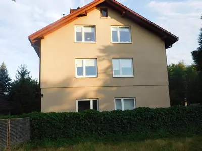 a house with a hedge in front of it at Pokoje gościnne Barka in Wadowice