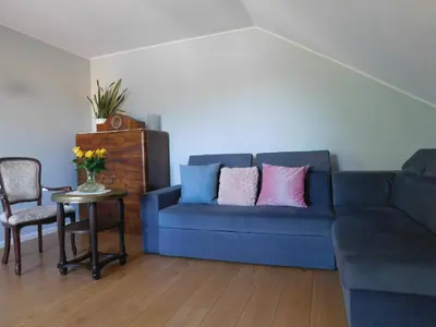 a living room with a blue couch with pink and blue pillows at Pokoje gościnne Barka in Wadowice