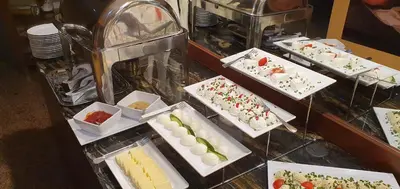 a bunch of desserts on display in a buffet at Domus Mater Hotel in Kraków