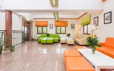 a waiting room at a hospital with orange and green furniture at Domus Mater Hotel in Kraków