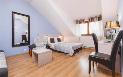 a bedroom with a bed and a chair at Domus Mater Hotel in Kraków