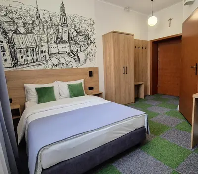 a bedroom with a bed with a drawing on the wall at Domus Mater Hotel in Kraków