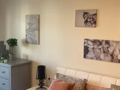a living room with a couch and paintings on the wall at Rajska 3 ap 206 by Atrium Apartments in Kraków