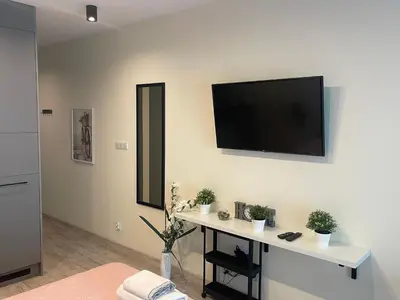 a living room with a flat screen tv on a wall at Rajska 3 ap 206 by Atrium Apartments in Kraków