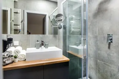 a bathroom with a sink and a glass shower at Rajska 3 ap 206 by Atrium Apartments in Kraków