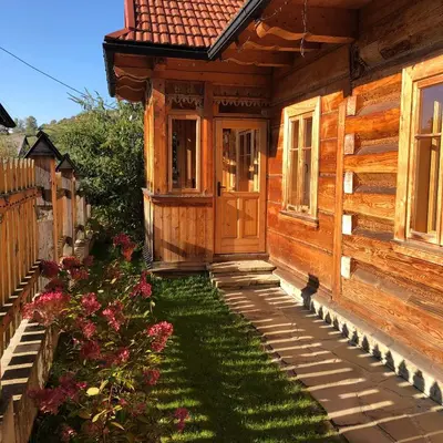 a front door of a wooden house with a yard at Góralskie domy w Łostówce in Łostówka
