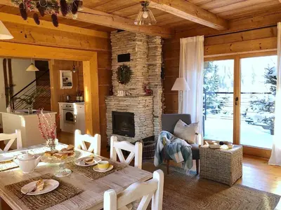 a living room with a table and a fireplace at Góralskie domy w Łostówce in Łostówka