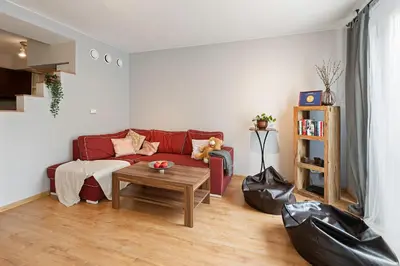 a living room with a red couch and a table at Negroni Apartments in Kraków