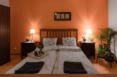 a bedroom with a large bed with two tables and two lamps at Negroni Apartments in Kraków
