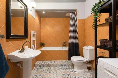a bathroom with a toilet and a sink and a tub at Negroni Apartments in Kraków