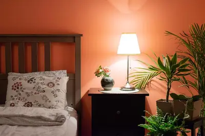 a bedroom with a bed with a lamp and plants at Negroni Apartments in Kraków