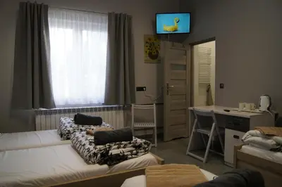 a room with two beds and a desk and a window at OLIVIA in Osiek