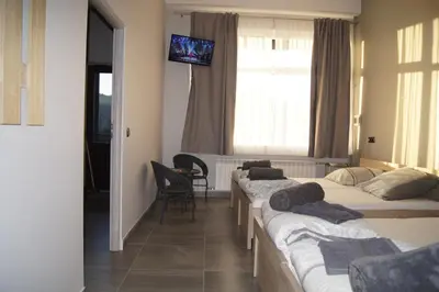 a room with four beds and a tv on the wall at OLIVIA in Osiek