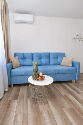 a living room with a blue couch and a table at Apartamenty Majka in Zator