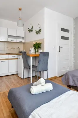 a bedroom with a bed and a table with chairs at Apartamenty Majka in Zator