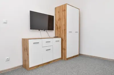 a room with a tv and a dresser with a mirror at Apartamenty Majka in Zator