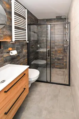 a bathroom with a shower with a toilet and a sink at Apartamenty Majka in Zator
