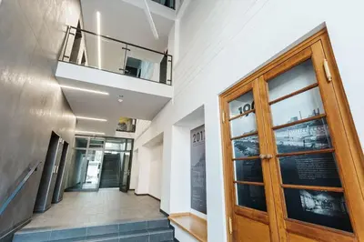 a hallway with a wooden door and stairs at Singer Retro Studio in Kazimierz in Kraków