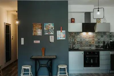 a kitchen with a counter and stools in a room at Singer Retro Studio in Kazimierz in Kraków