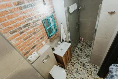 a bathroom with a brick wall and a sink at Singer Retro Studio in Kazimierz in Kraków