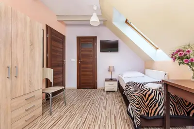 a room with a bed and a desk with a tv at RYSIÓWKA pokoje gościnne in Modlniczka