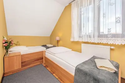 two beds in a small room with a window at RYSIÓWKA pokoje gościnne in Modlniczka