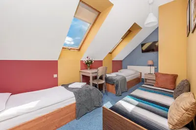 a hotel room with two beds and a desk at RYSIÓWKA pokoje gościnne in Modlniczka
