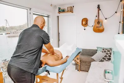 a man giving a woman a massage in a chair at Costa del Kryspi Całoroczne Domy na Wodzie in Cholerzyn