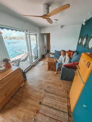 a man sitting on a couch in a living room at Costa del Kryspi Całoroczne Domy na Wodzie in Cholerzyn