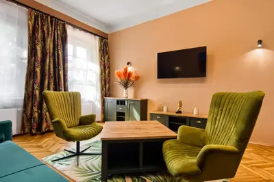 a living room with a table and two chairs and a tv at Mikołajska 5 Apartments in Kraków