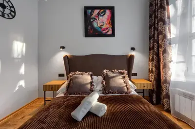 a teddy bear sitting on a bed in a room at Mikołajska 5 Apartments in Kraków