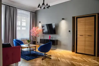 a living room with a table and chairs and a television at Mikołajska 5 Apartments in Kraków