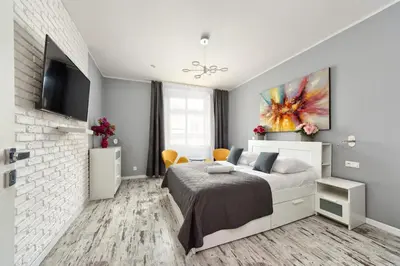 a white bedroom with a bed and a tv at Mikołajska 5 Apartments in Kraków