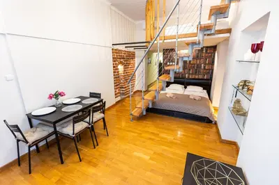 a room with a bed and a table and chairs at VINTAGE SENACKA APARTMENTS in Kraków