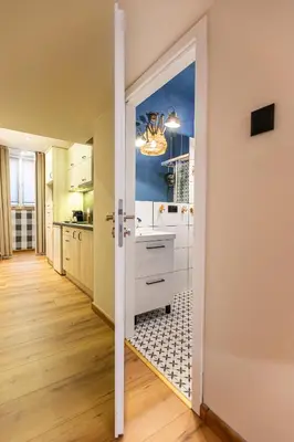 a kitchen with white cabinets and a mirror on the door at VINTAGE SENACKA APARTMENTS in Kraków