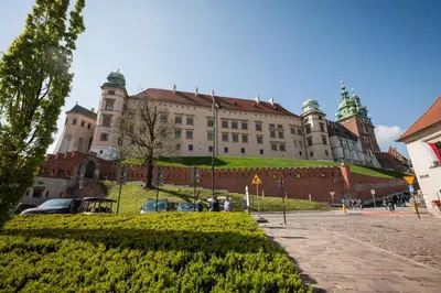 a large building with a hedge in front of it at VINTAGE SENACKA APARTMENTS in Kraków