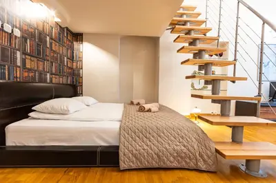 a bedroom with a bed and a spiral staircase at VINTAGE SENACKA APARTMENTS in Kraków