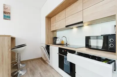 a kitchen with a microwave and a counter top at Tauron Arena Elegant Apartment Dąbska by Noclegi Renters in Kraków
