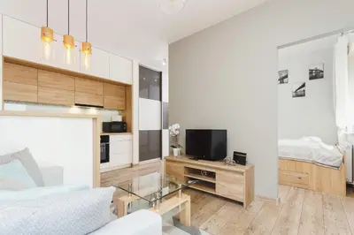 a living room with a bed and a tv and a couch at Tauron Arena Elegant Apartment Dąbska by Noclegi Renters in Kraków