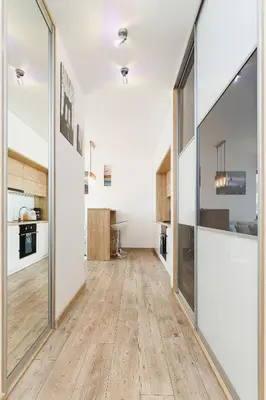 a hallway with a large glass door and a kitchen at Tauron Arena Elegant Apartment Dąbska by Noclegi Renters in Kraków