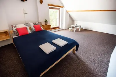 a bedroom with a large blue bed with red pillows at Cracow Family House in Kraków